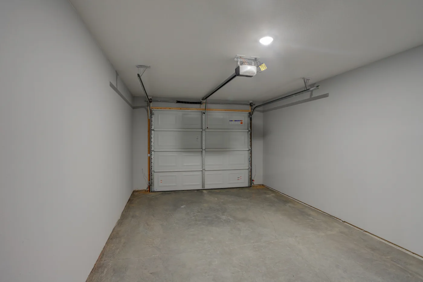 The clean attached single-car garage inside an Orchard Estates duplex home.